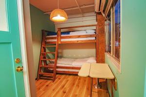 大阪HOSTEL CHILLAX的小房间设有双层床和桌子