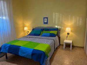 塞拉韦扎Casa tra gli ulivi vicino al mare的一间卧室配有蓝色和绿色的床