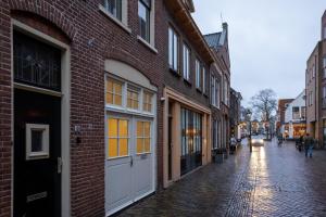 阿尔克马尔Drive-in appartement centrum Alkmaar的老城区的鹅卵石街道,建筑
