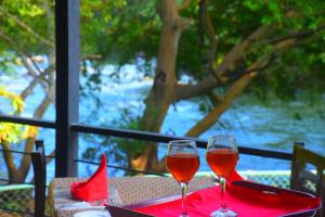 达瓦拉维Sunwin River Cabana的桌子上放两杯红葡萄酒