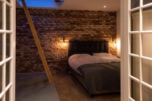 阿尔克马尔Drive-in appartement centrum Alkmaar的一间卧室设有砖墙和一张床