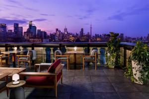 多伦多多伦多柏悦酒店的一个带桌椅的屋顶露台,享有城市天际线