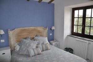 安圭拉萨巴齐亚La Villa di Augusto的一间卧室拥有蓝色的墙壁,配有一张带枕头的床。