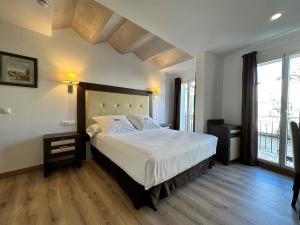 托莱多Antídoto Rooms Zocodover的一间卧室设有一张大床和一个大窗户