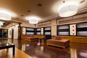 上山市有馬館旅馆的大堂设有两把椅子和桌子,窗户