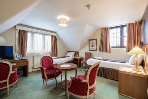 克劳利Barrington Lodge的酒店客房带两张床和一张桌子以及椅子。