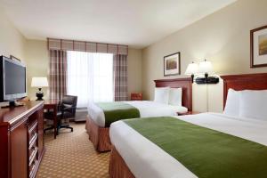 吉列吉莱特卡尔森江山旅馆&套房酒店的酒店客房设有两张床和一台平面电视。