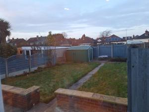 伍尔弗汉普顿Uplands Grove Bungalow的后院设有带围栏和房屋的院子