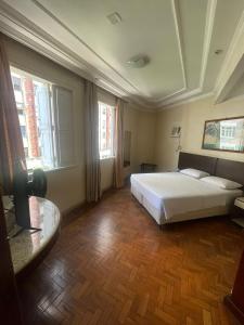 贝洛奥里藏特巴西宫酒店的卧室配有床、桌子和窗户。