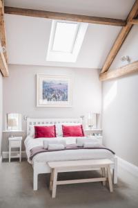 Barnetby le WoldThe Old Granary的卧室配有带红色枕头的白色床
