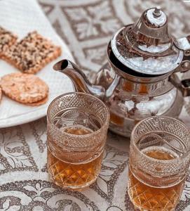 马拉喀什The magic of camping的茶壶和桌子上的两杯茶