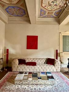 摩德纳Domus Tua的客厅配有白色沙发和红色绘画