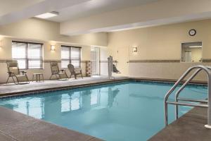 多森Comfort Inn & Suites的一个带椅子和桌子的大型游泳池