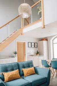 Barnetby le WoldThe Old Granary的客厅设有蓝色的沙发和楼梯。