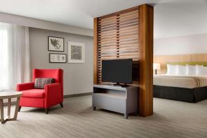西塔科卡尔森西雅图塔科马国际机场华盛顿江山旅馆的酒店客房配有一张床、一台电视和一张红色椅子。