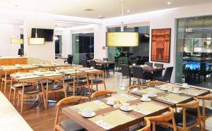 莱昂莱昂雷迪森珀里弗姆广场酒店的用餐室配有木桌和椅子