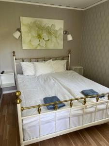 JämshögLiljenborg的卧室配有一张挂有花卉画的床铺。