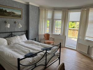 JämshögLiljenborg的一间卧室配有一张床、一把椅子和窗户。