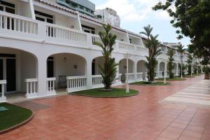 巴拿马城Hotel El Panama by Faranda Grand, a member of Radisson Individuals的庭院里一排种有棕榈树的白色建筑