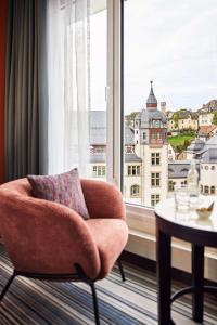 耶拿Dorint Hotel Esplanade Jena的窗户房间里一张椅子和一张桌子