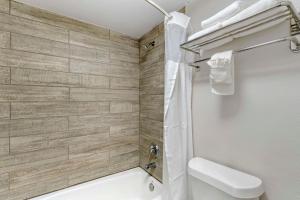 奥兰多Quality Inn & Suites Orlando East - UCF Area的浴室配有白色卫生间和淋浴。