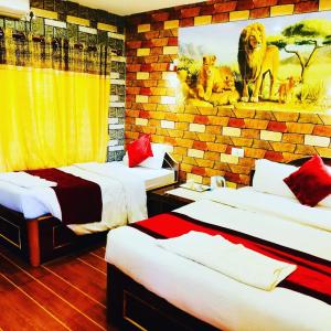 索拉哈Chitwan Forest Resort , Chitwan National Park的一间设有两张床的房间,墙上挂着狮子照片