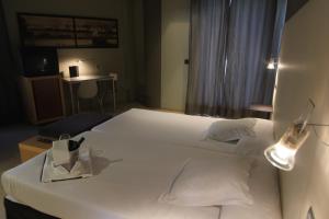 费罗尔Hotel Almirante的一间卧室配有一张带两盏灯的大型白色床。