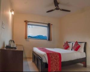 兰纳加Mannat Corbett Resort的一间卧室配有一张带吊扇和窗户的床。