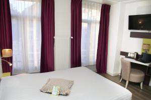 里尔里尔格兰德酒店的酒店客房,配有红色窗帘的床
