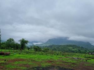 GhātgarhRaje Bhosale Farm的山地,有围栏的田野