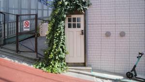 东京almond hostel & cafe Shibuya的常春藤长在建筑物边的门