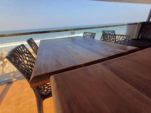 瓦尔卡拉East West Beach Resorts的一张木桌和椅子,背靠大海