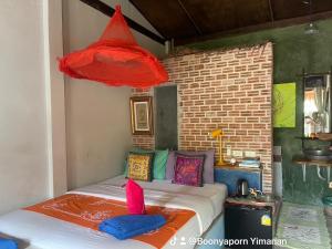 达叻府达勒艺术家广场酒店的一间卧室配有带色彩缤纷枕头的床