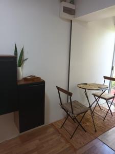 科洛尼亚-德尔萨克拉门托Leia's House的客房设有2把椅子、桌子和冰箱。