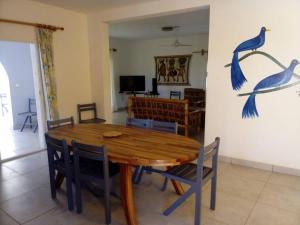 PalmarinLes Filaos-Villa entre fleuve saloum et ocean的用餐室配有木桌和墙上的蓝色鸟类