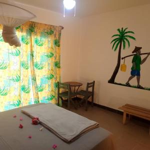 PalmarinLes Filaos-Villa entre fleuve saloum et ocean的一间房间,配有一张床和一幅画,画着一个步行的男人的四肢