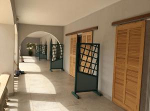 PalmarinLes Filaos-Villa entre fleuve saloum et ocean的走廊设有绿门,铺有瓷砖地板