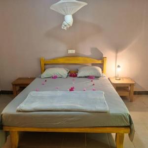 PalmarinLes Filaos-Villa entre fleuve saloum et ocean的一间卧室配有一张带鲜花的大床