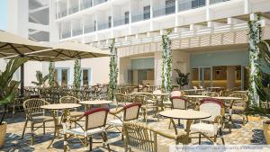 托雷坎内格兰圣立那酒店的室外餐厅设有桌椅和遮阳伞。