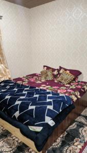 斯利那加Luminaire Homestay的一张带蓝色棉被和枕头的床