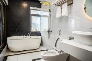 岘港Phu My Hai Hotel的白色的浴室设有卫生间和水槽。