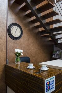 敖德萨Apart Hotel Kvartira 1的一张桌子,上面有两个杯子和墙上的时钟