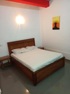比绍HOTEL BADINCA Alojamento Low Cost in Bissau avenida FRANCISCO MENDES的卧室配有一张床,墙上有灯