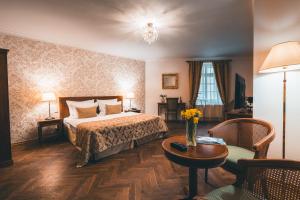 布拉格阿皮亚酒店的酒店客房配有一张床铺和一张桌子。