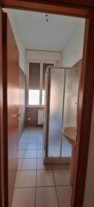 博洛尼亚Via Creti & Via Mazza Rooms的一间带冰箱的浴室,铺有瓷砖地板。