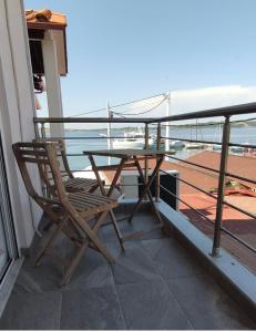 阿莫利亚尼岛elenamou seaview rooms的一张木椅,位于带桌子的阳台