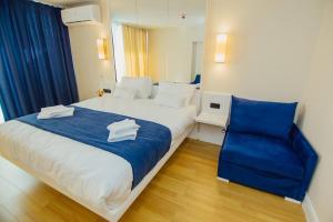 巴统Orbi City Batumi的一间卧室配有一张大床和一张蓝色椅子