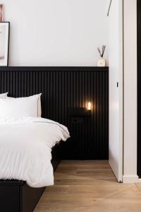 安特卫普Gorgeous getaway in the old city centre of Antwerp的一间卧室配有黑色床头板和白色的床