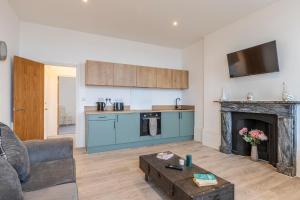 KentSeaside Serenity: Stylish Sea View Apartments in Herne Bay的客厅设有厨房和壁炉