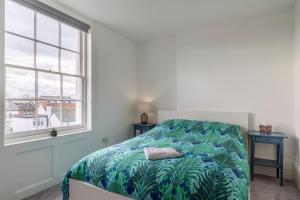 KentSeaside Serenity: Stylish Sea View Apartments in Herne Bay的一间卧室配有一张带蓝色和绿色毯子的床